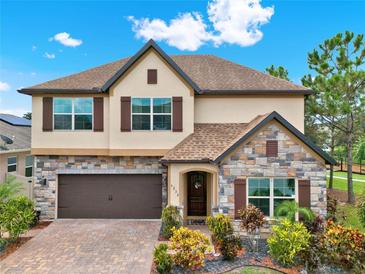 Two-story house exterior, stone accents, brown garage door, and landscaping at 5232 Villa Rosa Ave, St Cloud, FL 34771