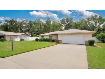 Single-story home with a one-car garage and landscaped lawn at 3472 Country Walk Dr, Port Orange, FL 32129