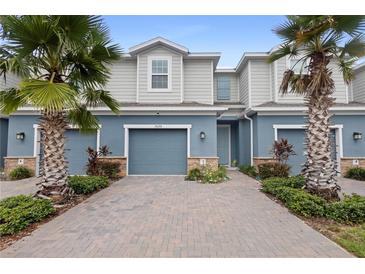 Two-story townhome with gray siding and blue garage doors at 1820 Holden Ridge Ln, Clermont, FL 34715