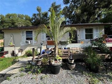 Tan house with a wooden deck, tropical plants, and gravel landscaping at 1117 E Hubbard Ave, Deland, FL 32724