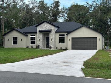 Two-story house with stone accents and a two-car garage at 1420 Lake Harney Rd, Geneva, FL 32732