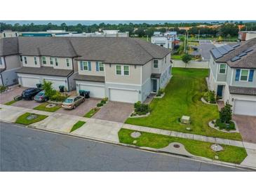 Aerial view of townhouses with landscaped yards and parking at 15259 Willow Arbor Cir, Orlando, FL 32824