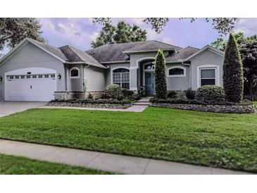 Two story home with attached garage and manicured lawn at 8208 Vineland Oaks Blvd, Orlando, FL 32835