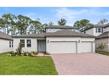 Two-story home with three car garage and landscaped yard at 2153 Divot Dr, Daytona Beach, FL 32124
