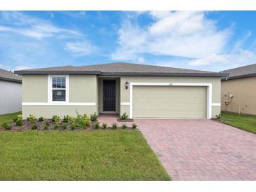 House exterior featuring a two-car garage and well-maintained landscaping at 3174 Viceroy Ct, Poinciana, FL 34759