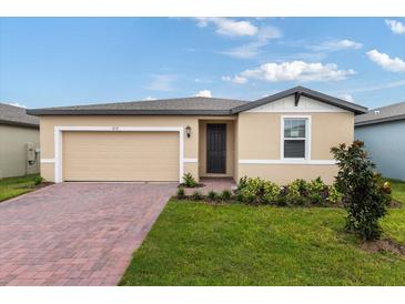 Tan house with dark brown door and brick driveway at 3170 Viceroy Ct, Poinciana, FL 34759