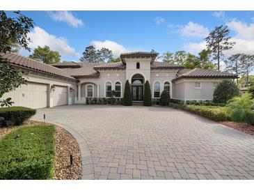 Luxury home exterior with a large driveway and manicured landscaping at 213 Arezzo Ct, Sanford, FL 32771