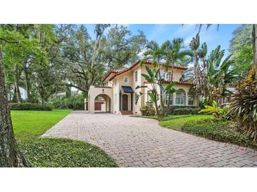 Spanish style home with tile roof, arched entry, and lush landscaping at 732 Edgewater Dr, Orlando, FL 32804