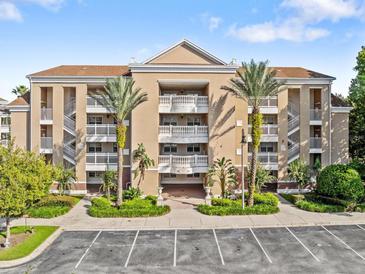 Beige three-story building with balconies and palm trees at 7651 Whisper Way # 401, Reunion, FL 34747