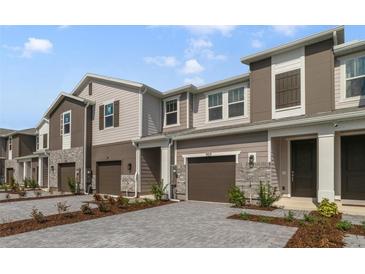 Modern townhome with gray siding, two-car garage, and landscaped front at 707 Southern Edge Way, Sanford, FL 32771