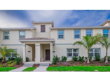 Two-story townhome with front porch, landscaping, and palm trees at 4804 Memories Ln, Kissimmee, FL 34746
