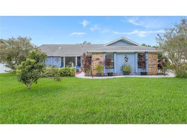 Cute light blue house with well-maintained lawn and landscaping at 8692 Vesta Ter, Orlando, FL 32825