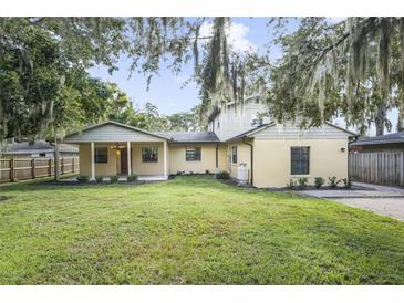 Spacious backyard with grassy lawn and mature trees at 5625 Chipola Cir, Orlando, FL 32839