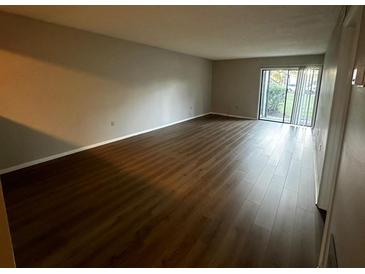 Spacious living room with dark laminate wood flooring at 317 Scottsdale Sq # 317, Winter Park, FL 32792