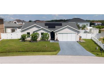 One-story house with solar panels and double garage at 242 Abbotsbury Dr, Kissimmee, FL 34758