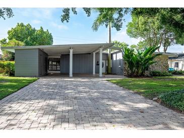 Mid-century modern home with a brick driveway and lush landscaping at 2148 Chippewa Trl, Maitland, FL 32751