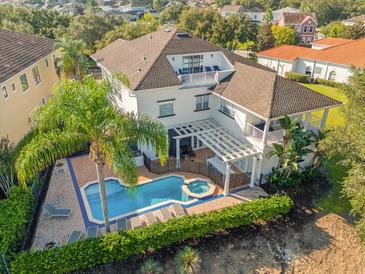 Aerial view of a home with a large pool and patio at 7481 Gathering Loop, Reunion, FL 34747