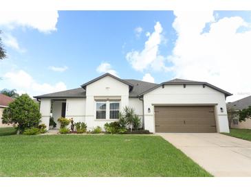 House exterior featuring two-car garage and landscaping at 3094 Anquilla Ave, Clermont, FL 34711