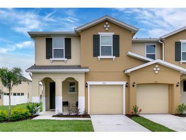 Two story tan house with dark shutters, two car garage, and front porch at 5116 Killarney Way, Kissimmee, FL 34746