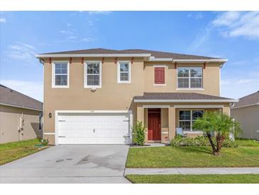 Two-story house with a two-car garage and red door at 1139 August Sky Dr, Deltona, FL 32738