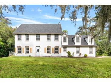 Two story house with shutters and lawn at 12200 Treetop Ct, Orlando, FL 32832