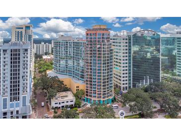 Aerial view of a high-rise building in the city with surrounding buildings and lake at 322 E Central Blvd # 1214, Orlando, FL 32801
