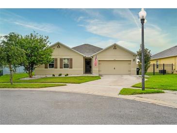 Tan house with a two-car garage and well-manicured lawn at 3650 Yacobian Pl, Orlando, FL 32824