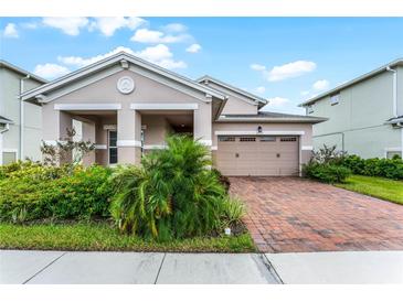 Two-story house with tan exterior and brick driveway at 2717 Greenlands St, St Cloud, FL 34772