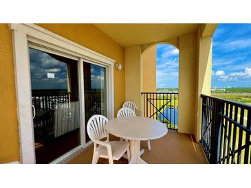 Balcony with table and chairs overlooking a lake at 8101 Resort Village Dr, Orlando, FL 32821