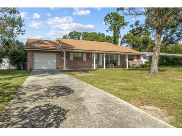 Brick ranch home with carport and lawn at 1421 Avenue G Ne, Winter Haven, FL 33881