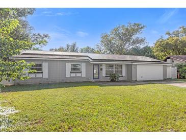 Gray house with solar panels, white shutters, and a well-maintained lawn at 630 Martin Ave, Altamonte Springs, FL 32701