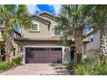 Two story house with a double garage and palm trees at 8869 Rhodes St, Kissimmee, FL 34747