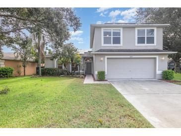 Two-story house with gray siding, two-car garage, and a well-maintained lawn at 2807 Strand Loop Ct, Oviedo, FL 32765