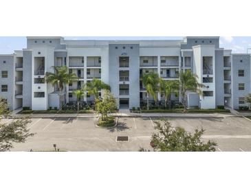 Modern apartment building with ample parking and lush landscaping at 4751 Clock Tower Dr # 105, Kissimmee, FL 34746