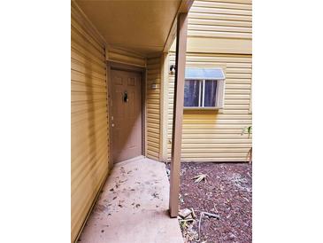 Condo building exterior with a brown door and small window at 1916 Lake Atriums Cir # 25, Orlando, FL 32839