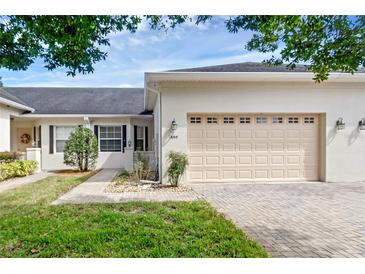 House exterior featuring a two-car garage and a well-maintained front yard at 1049 Green Gate Blvd, Groveland, FL 34736