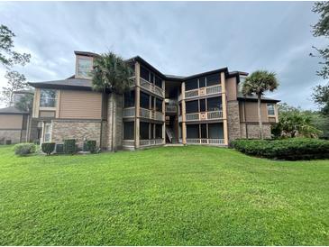 Exterior view of a multi-story condo building with lush landscaping at 470 S Pin Oak Pl # 204, Longwood, FL 32779