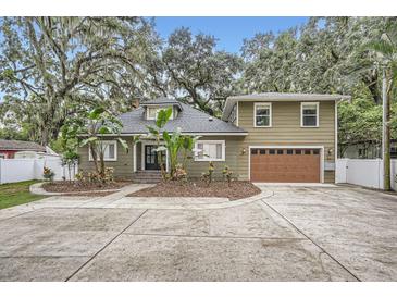 Two-story house with a large driveway and landscaped front yard at 734 S Mills Ave, Orlando, FL 32801