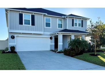 Two-story house with gray siding, white garage door, and landscaping at 2346 Upland Ln, Apopka, FL 32712