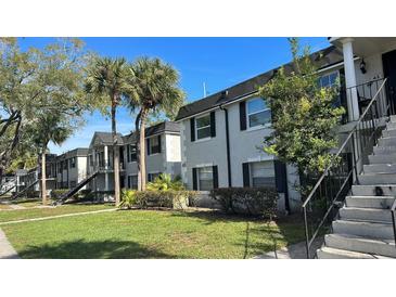 Exterior view of an apartment building with lush landscaping at 7622 Forest City Rd # E, Orlando, FL 32810