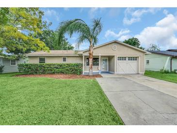 Tan one-story house with attached garage and palm tree at 107 Montana Ave, Saint Cloud, FL 34769