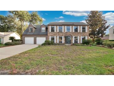 Two-story brick house with a two-car garage and manicured lawn at 7972 Snowberry Cir, Orlando, FL 32819