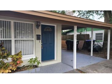 Updated house exterior with freshly painted walls and a teal front door at 5107 Indialantic Dr, Orlando, FL 32808