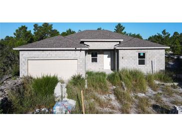 New construction home with block exterior and two-car garage at 619 Alafia Pl, Poinciana, FL 34759