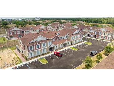 Aerial view of a community with townhouses and ample parking at 7514 Sunflower Cir, Kissimmee, FL 34747