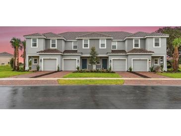 Three-unit townhome building with attached garages and landscaping at 195 River Front Way, Edgewater, FL 32141