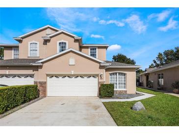 Two-story house with a beige exterior, three-car garage, and landscaping at 349 La Creek Ct, Debary, FL 32713