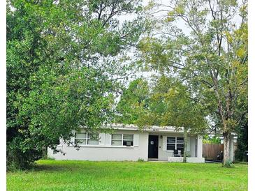 Single-story home with a spacious lawn and mature trees at 1250 Saint James Rd, Orlando, FL 32808