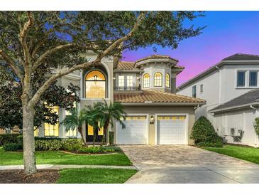 Grand two story house with a three-car garage and manicured landscaping at 364 Muirfield Loop, Reunion, FL 34747