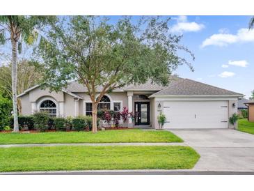 One-story home with a two-car garage and manicured lawn at 1409 Sutton Island Dr, Deland, FL 32724